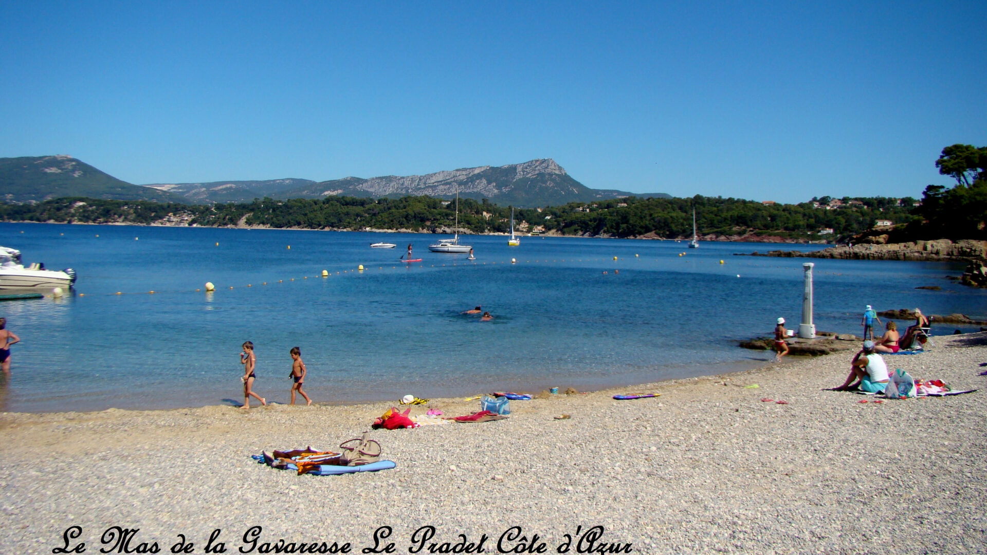 Plage de sable naturel au mas de la gavaresse avec des enfants jouant sous le soleil