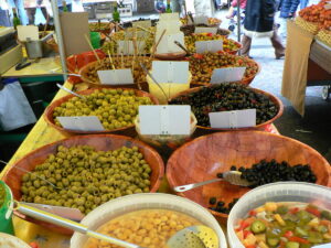 Marché provençal avec des produits artisanaux tels que olives, céramique et huile essentielle.