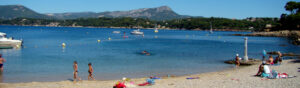 Vue de la plage des Oursinières au Pradet avec galets, mer turquoise et rochers en arrière-plan