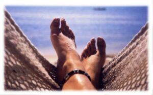 Pieds de femme dans un hamac à l'ombre | Sieste estivale décontractée

