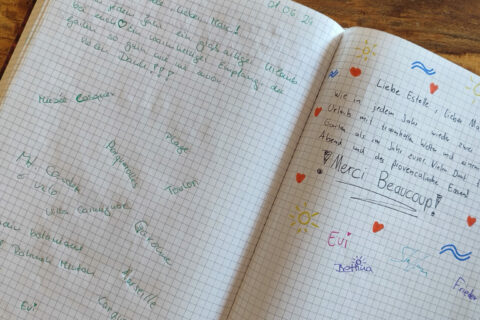 Un avis écrit à la main sur une page de papier, avec un commentaire positif sur l'accueil, le gîte et la qualité du séjour, signé par un locataire satisfait.