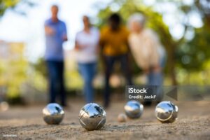 Gros plan sur des boules de pétanque et des joueurs en arrière-plan