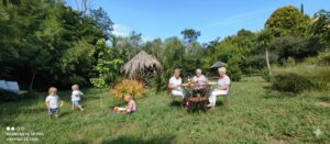 Famille et jeunes enfants s'amusant dans le grand jardin arboré du Mas de la Gavaresse au Pradet.