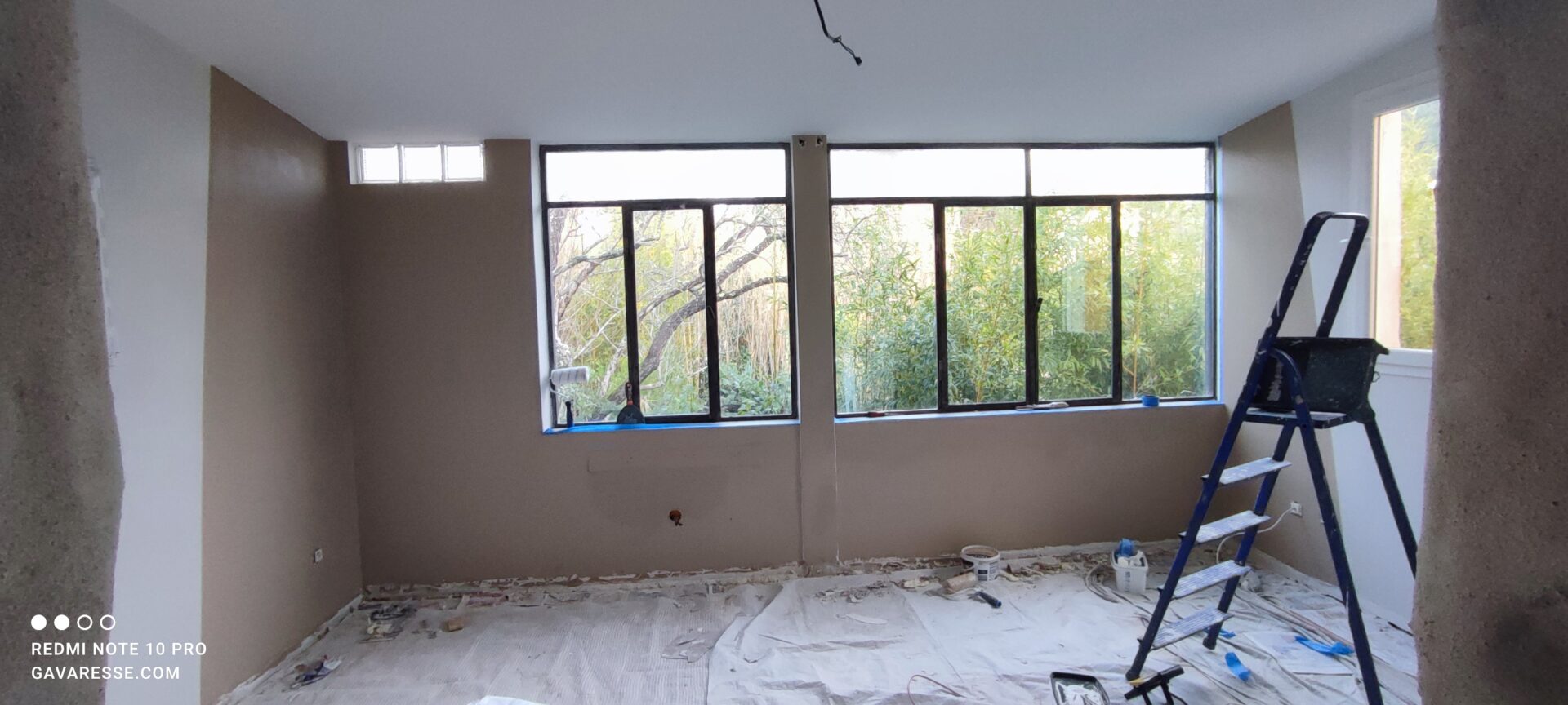 Préparation du chantier de rénovation dans le salon du gîte l'Orangeraie au Pradet, protection des sols avant la pose du plafond suspendu.